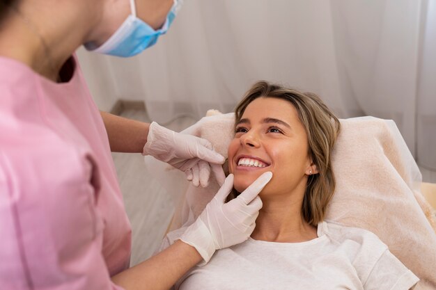 Feche a mulher sorridente recebendo preenchimento labial