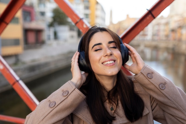 Feche a mulher sorridente usando fones de ouvido