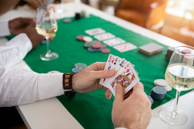 Feche a pessoa jogando pôquer com amigos