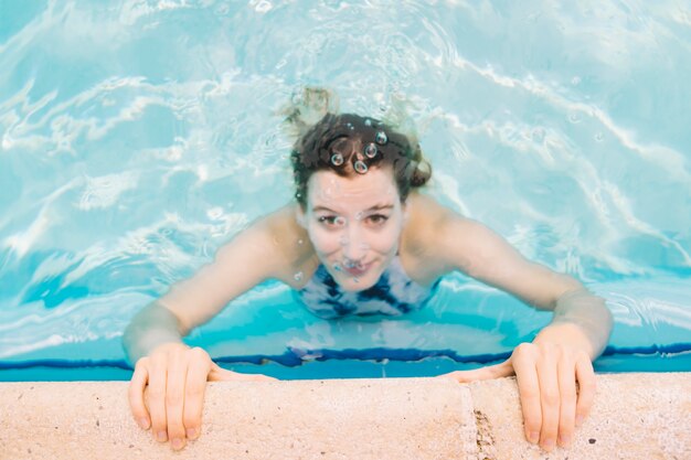 Feche a vista da mulher na beira da piscina