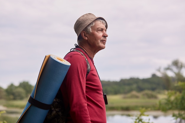 Feche acima da foto do perfil do homem idoso com mochila