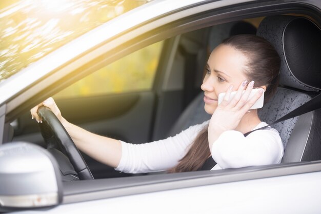 Feche acima das mãos femininas no volante