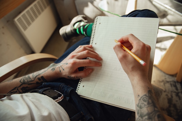 Feche acima das mãos masculinas, escrevendo em um conceito vazio de papel, educação e negócios
