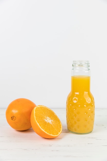 Feche acima do suco de laranja abriu a garrafa