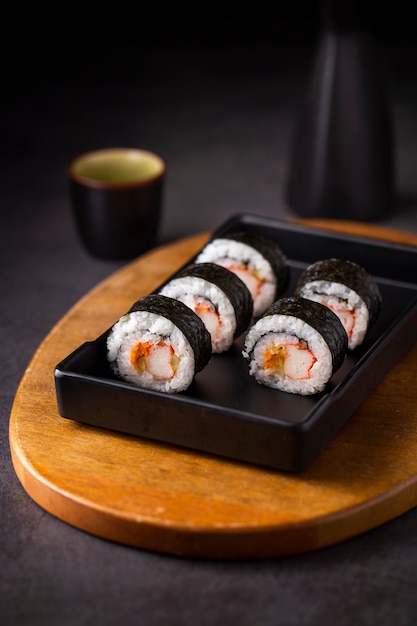 Feche acima dos rolos de sushi maki na ardósia preta