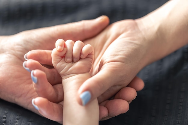 Foto grátis feche as mãos da mãe e da avó do bebê