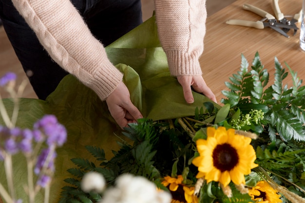 Feche as mãos envolvendo flores