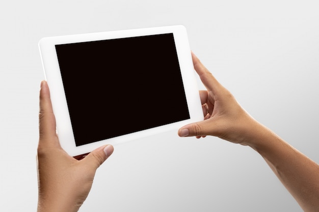 Feche as mãos masculinas segurando o tablet com tela em branco durante a visualização on-line de partidas e campeonatos de esporte popular em todo o mundo.