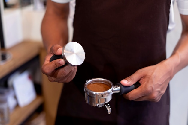 Feche as mãos preparando o café