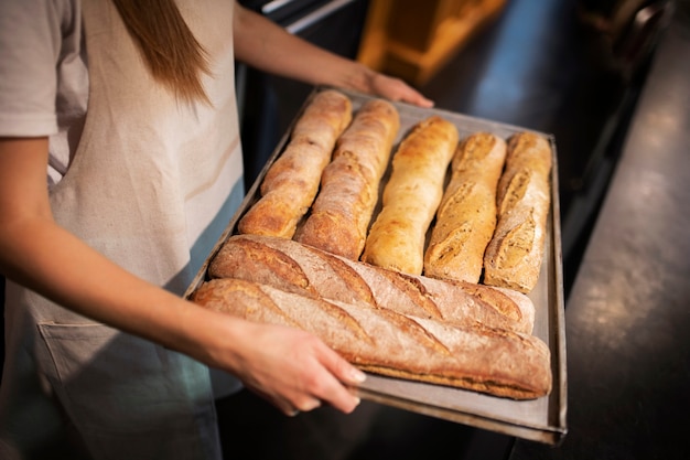 Feche as mãos segurando a bandeja com palitos de pão