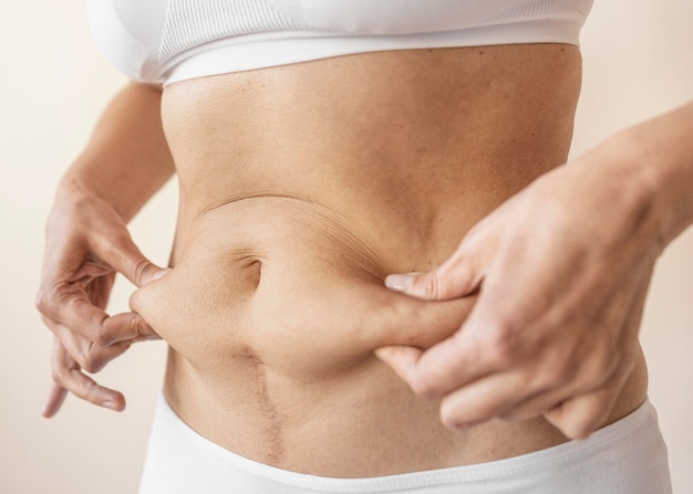 Feche as mãos segurando a barriga