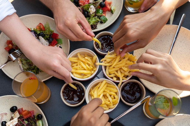 Feche as mãos segurando batatas fritas