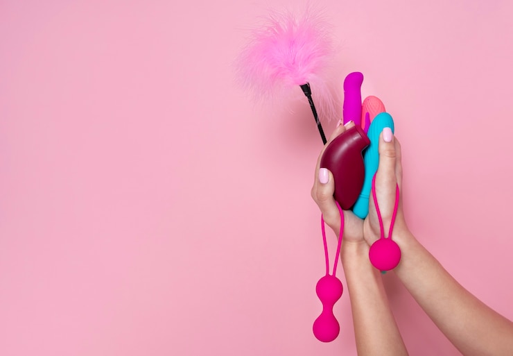 Foto grátis feche as mãos segurando brinquedos sexuais