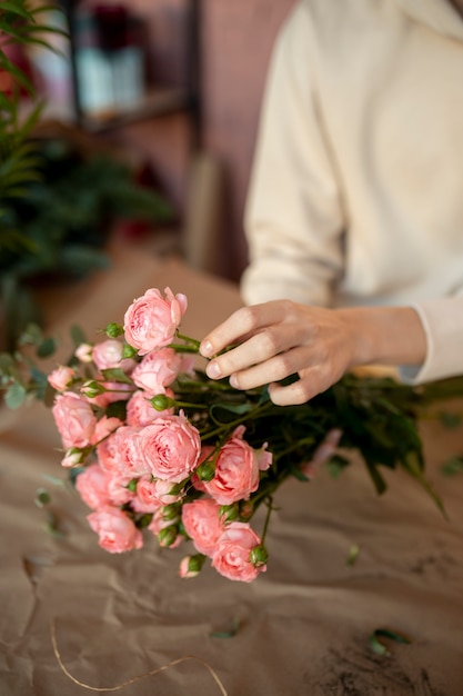 Foto grátis feche as mãos segurando flores