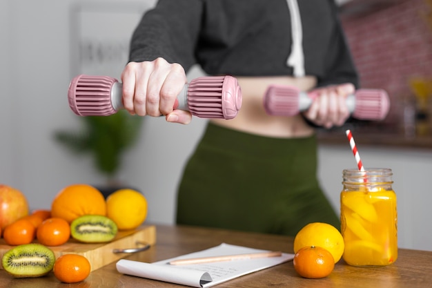 Foto grátis feche as mãos segurando halteres dentro de casa