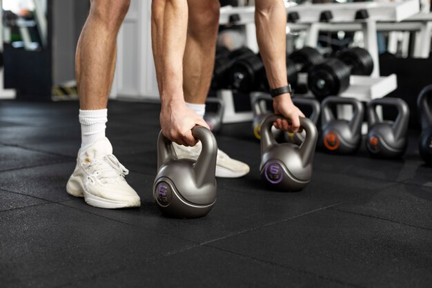 Feche as mãos segurando kettlebells