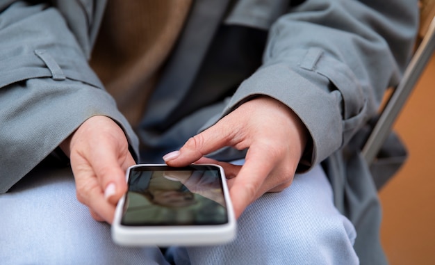 Feche as mãos segurando um smartphone