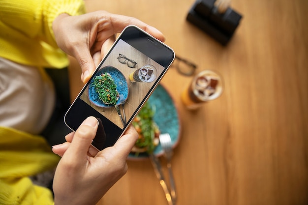 Foto grátis feche as mãos segurando um smartphone