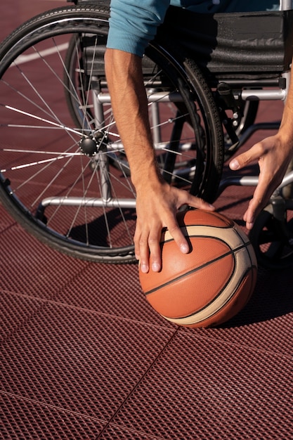 Feche as mãos segurando uma bola de basquete