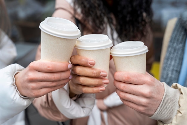 Foto grátis feche as mãos segurando xícaras de café