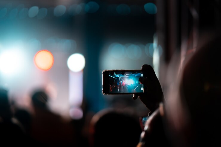 Foto grátis feche de gravação de vídeo com smartphone durante um show. imagem tonificada