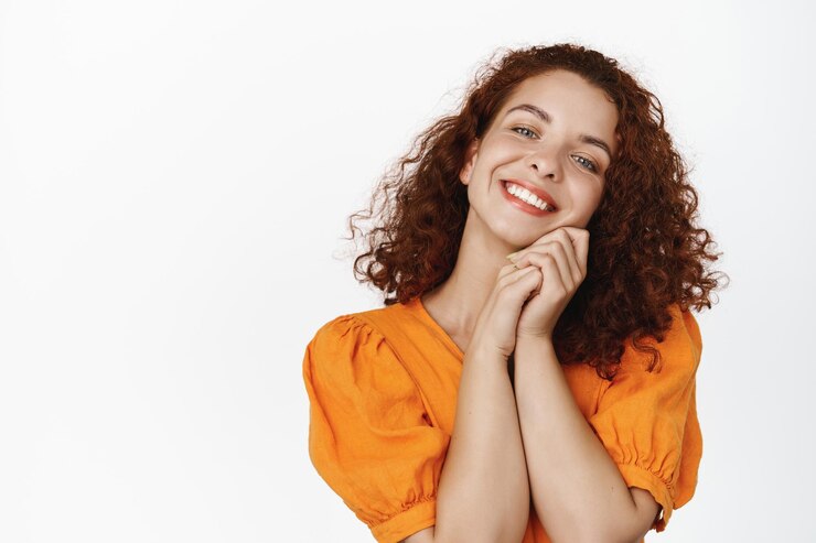Foto grátis feche de mulher bonita, macia e feliz com penteado curto encaracolado, olhando para a câmera satisfeito, sonhando acordado, contemplando a beleza, de pé sobre fundo branco.