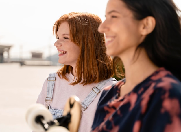 Foto grátis feche mulheres sorridentes com longboard