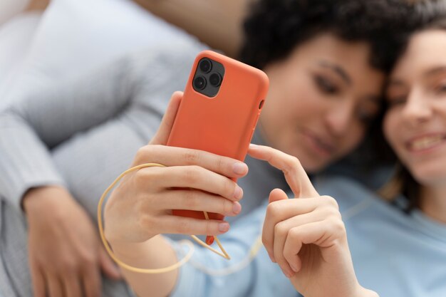 Feche o casal de lésbicas tomando selfie