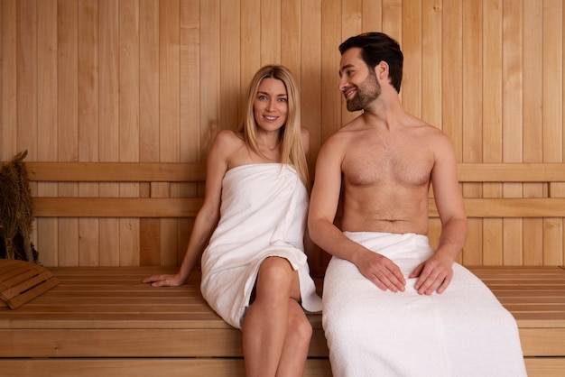 Feche o casal relaxando na sauna