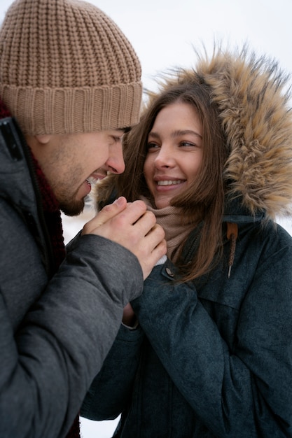 Feche o casal sorridente de mãos dadas