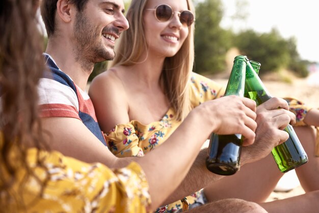 Feche o grupo de amigos fazendo um brinde comemorativo com cerveja