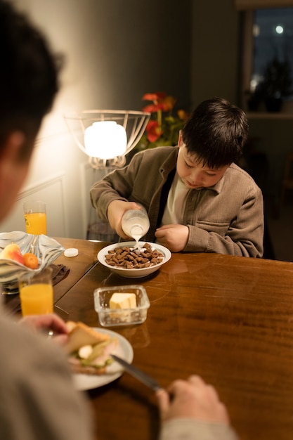 Feche o homem e a criança comendo