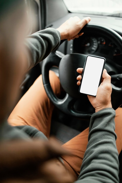 Feche o homem no carro com o celular