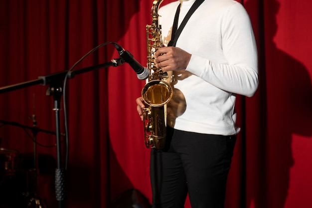 Foto grátis feche o músico tocando saxofone