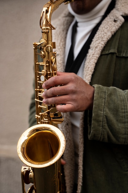 Feche o músico tocando saxofone