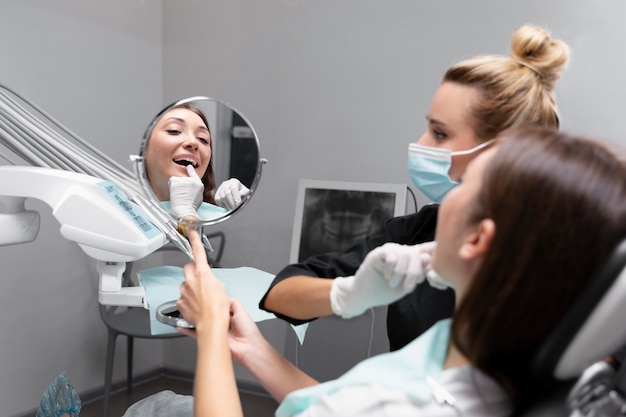 Foto grátis feche o paciente na consulta com o dentista