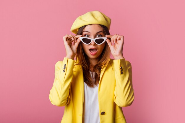 Feche o retrato da moda da mulher elegante de terno amarelo e boina.