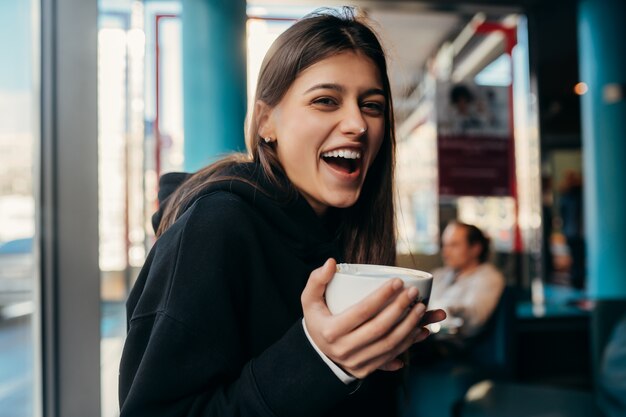 Feche o retrato da mulher bonita bebendo café.