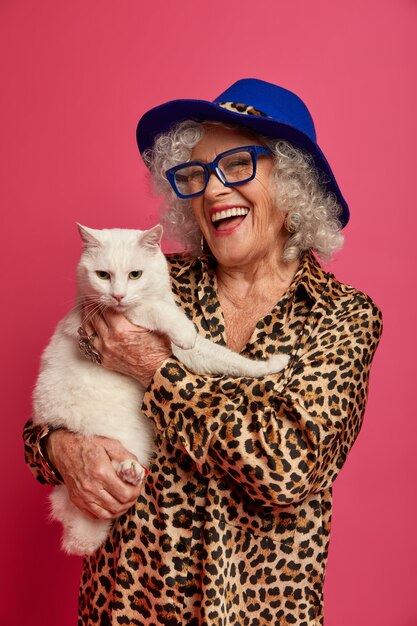 Foto grátis feche o retrato da vovó feliz e enrugada na moda com um lindo gato
