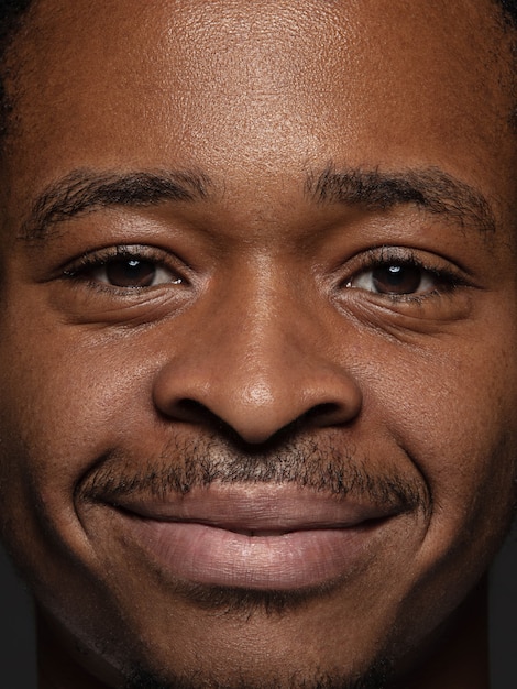 Feche o retrato de um homem afro-americano jovem e emocional. foto fotográfica altamente detalhada de um modelo masculino com pele bem cuidada e expressão facial brilhante. conceito de emoções humanas. olhando para a câmera.