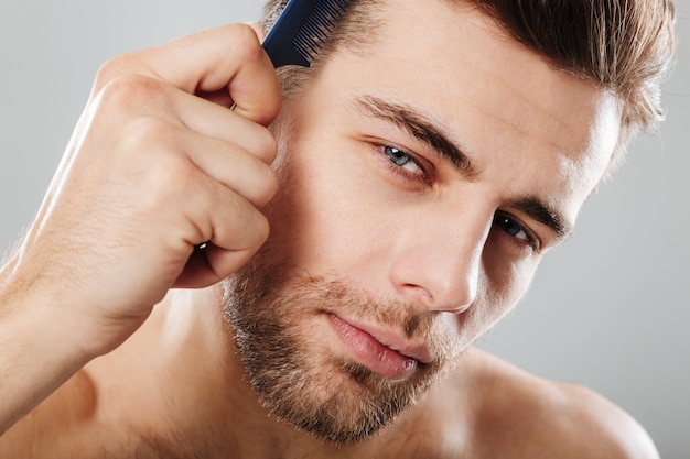 Foto grátis feche o retrato de um homem bonito, penteando o cabelo