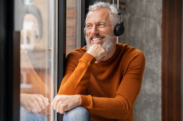 Feche o retrato de um homem sênior ouvindo música