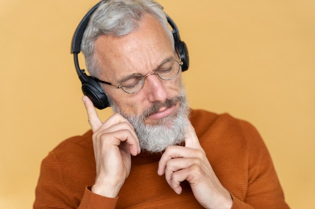 Feche o retrato de um homem sênior ouvindo música