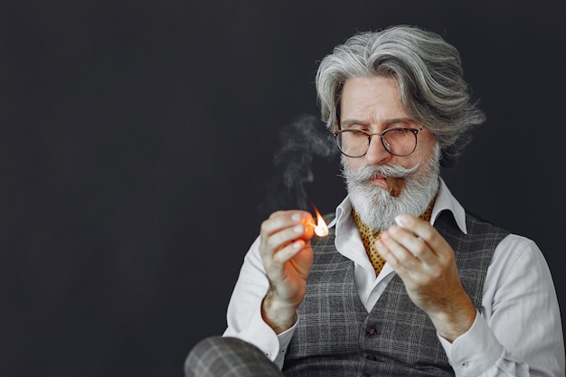 Feche o retrato de um homem sorridente à moda antiga. Avô com um charuto.