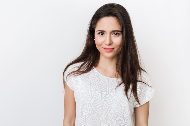 Feche o retrato de uma jovem bonita elegante sorrindo em uma camiseta branca, isolada, aparência natural, cabelos castanhos compridos