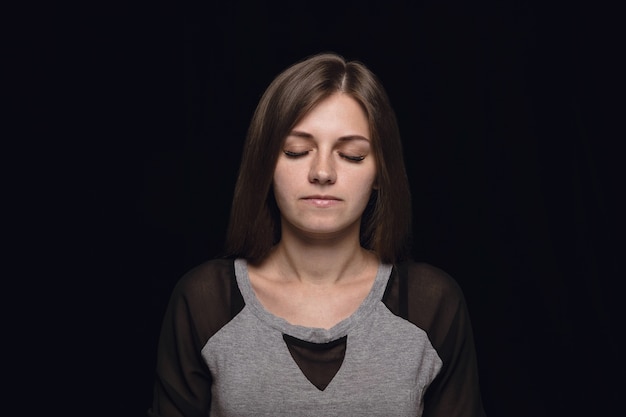 Feche o retrato de uma jovem isolada. modelo feminino com os olhos fechados. Pensativo. Expressão facial, natureza humana e conceito de emoções.