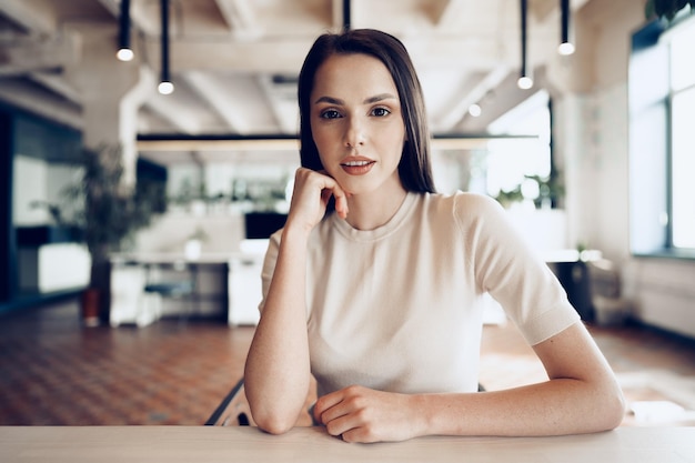 Feche o retrato de uma jovem que trabalha no escritório à mesa