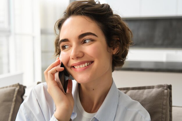 Feche o retrato de uma linda mulher sorridente falando em bate-papos de telefone celular em chamadas de smartphones someo
