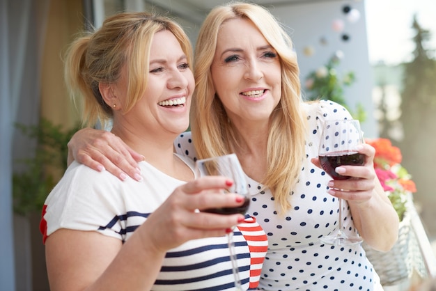 Feche o retrato de uma mulher com vinho na varanda