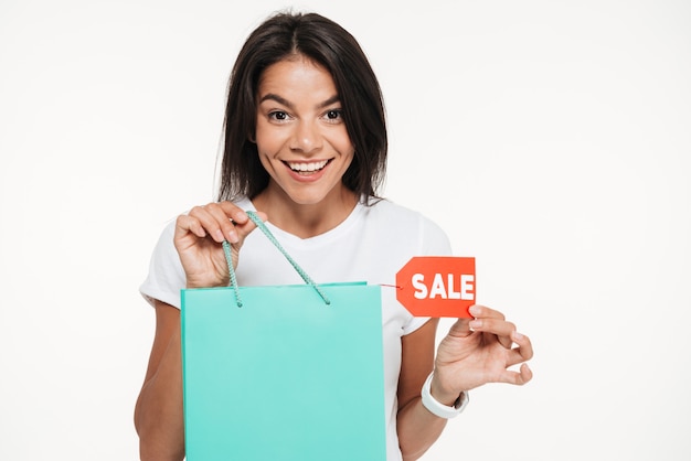 Feche o retrato de uma mulher feliz, segurando a sacola de compras